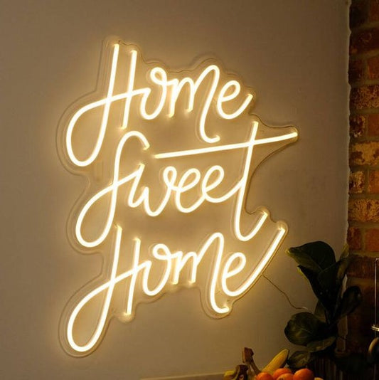 Brighten your space with a custom Home Sweet Home neon sign, perfect for adding a cozy and modern touch to your living room décor. Neon sign with 'Home Sweet Home' text on a wall.