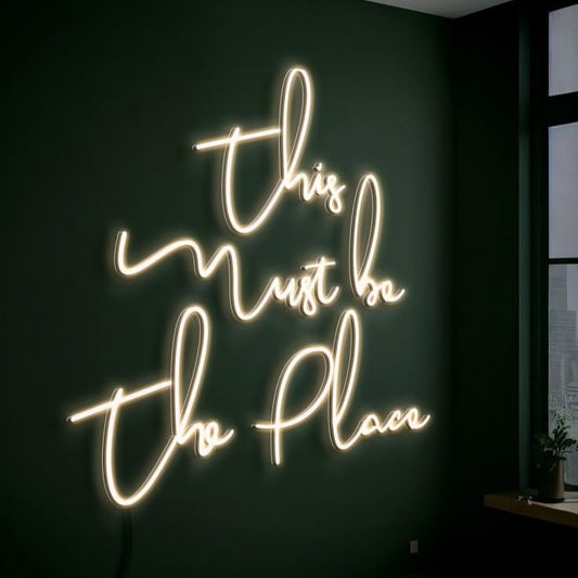 this must be the place Neon sign with 'this just be the place' on a dark wall