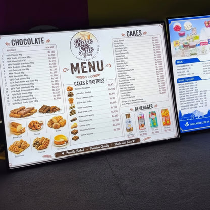 Backlit changeable paper menu board showing food products and prices at a café or bakery counter