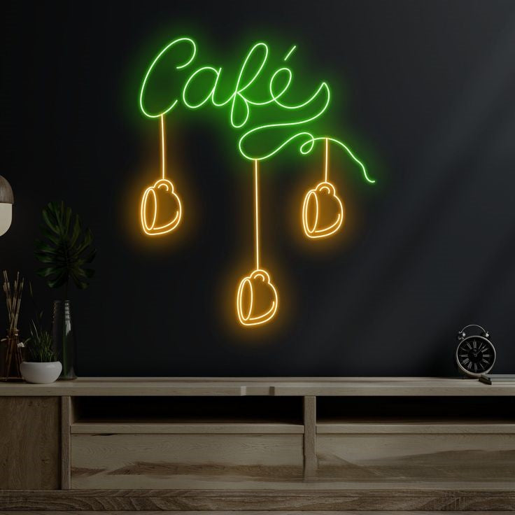 Cafe Neon Sign | Custom Neon Sign | Neon for Restaurants Neon sign with 'Café' and coffee bean designs on a dark wall.