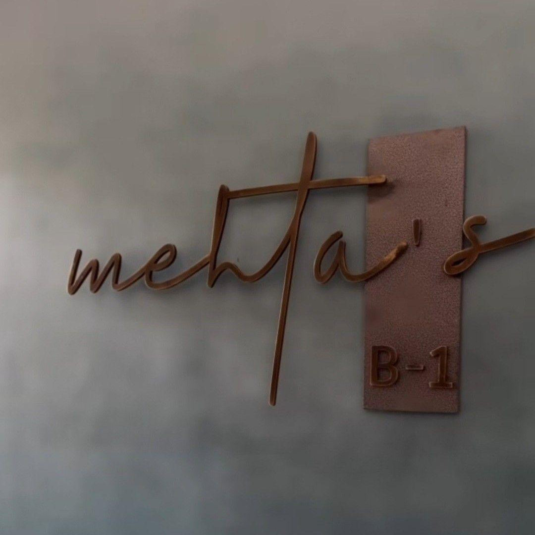 Luxury personalized metal house name sign featuring cursive family lettering and a matching address number on an exterior wall.