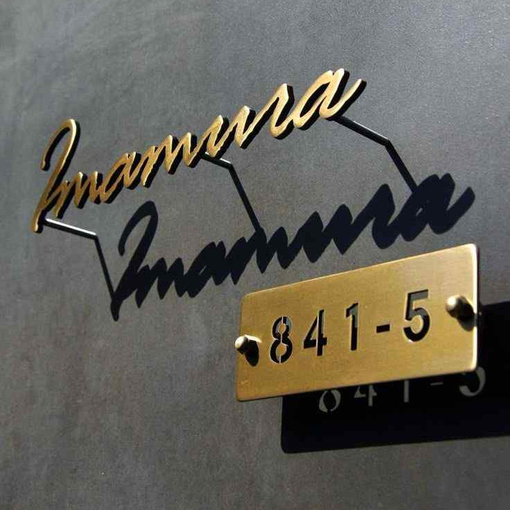 Luxury personalised home name sign with raised gold cursive lettering, black shadow effect, and gold rectangular house number plate.