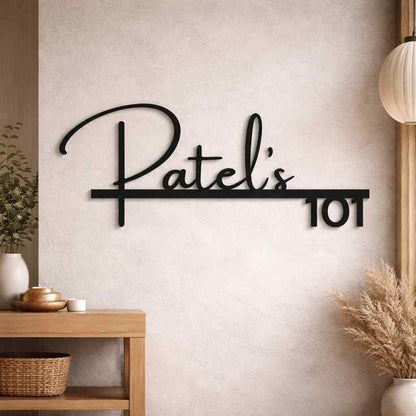Modern illuminated house name sign displaying Patel's 101 on a textured wall and wooden entrance panel.