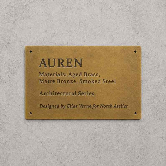 Premium antique brass-look nameplate with personalized lettering displayed on a dark stone wall and vertical wooden exterior cladding.