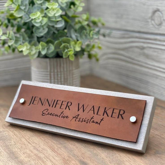 Premium personalised office desk name sign featuring a copper-tone plaque, black engraved lettering, and a light marble-effect base for an executive workspace.