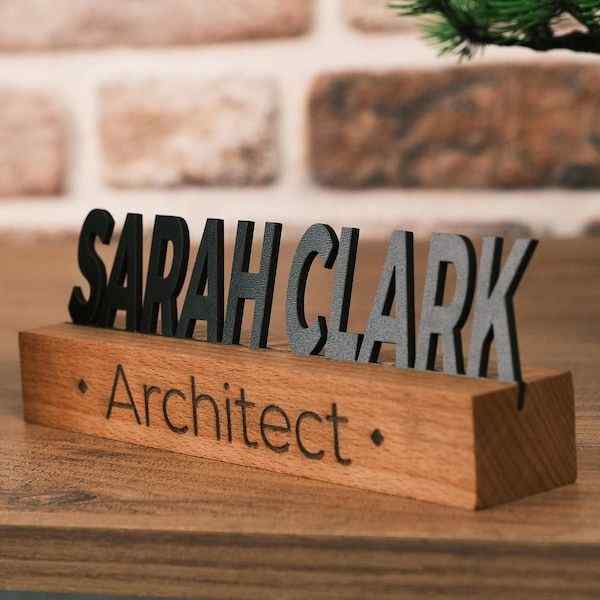 Premium personalised wooden name sign for architects featuring raised black lettering on a natural wood base, displayed on an executive office desk.