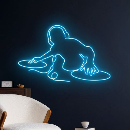 DJ Play Neon Sign | Custom Neon Sign | Neon for Bar, Restaurants Neon light silhouette of a person on a dark wall in a room with a chair and small table.