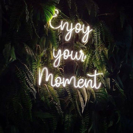 Enjoy your moment Neon Sign | Custom Neon Sign | Neon for Decoration Neon sign with 'Enjoy your moment' text surrounded by foliage