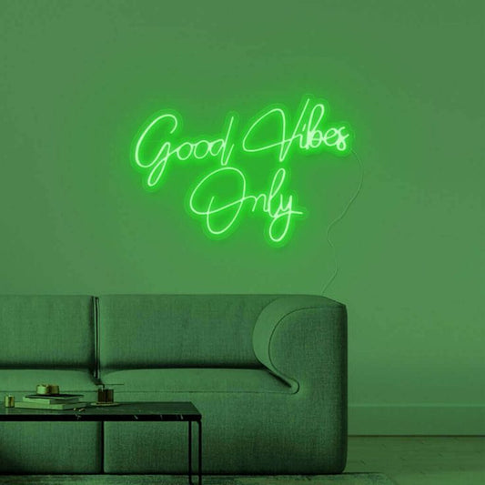 Good Vibes Only Neon Sign | Custom Neon Sign | Neon for Living Room Decor Neon sign with 'Good Vibes Only' on a green wall with a gray sofa.