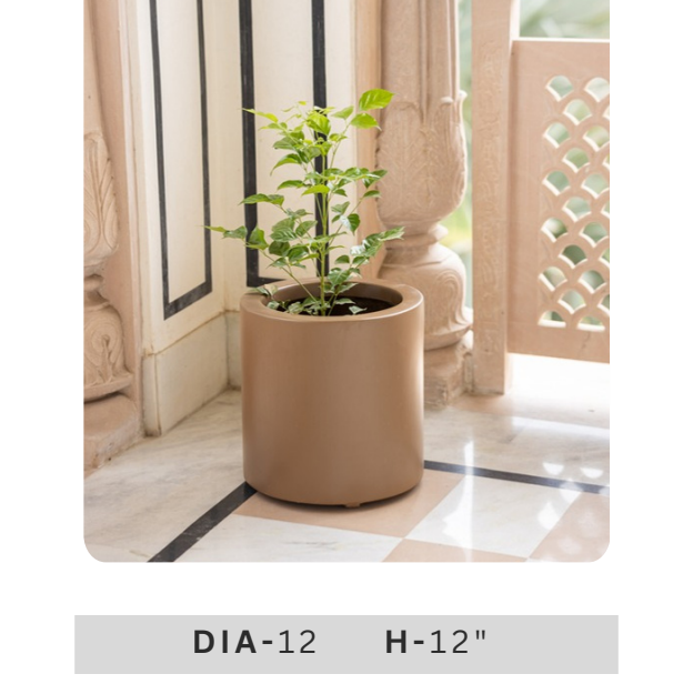small green artificial plant arrangement in a taupe brown cylindrical planter for indoor home and office decoration