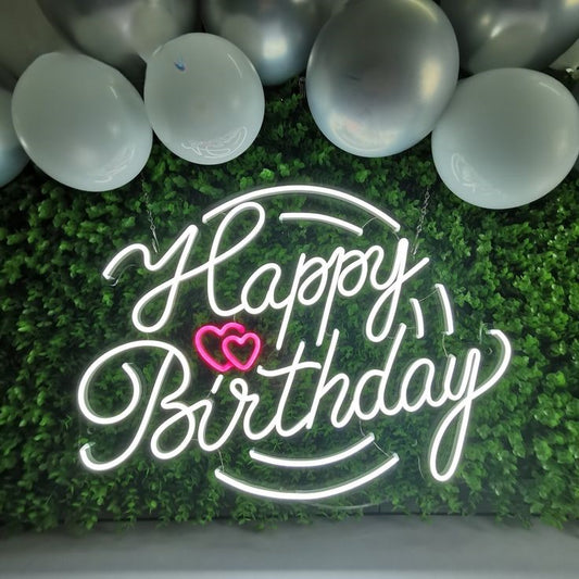 Happy Birthday Neon Sign | Custom Neon Sign | Neon for Living Room Decor Neon 'Happy Birthday' sign with a pink heart on a green wall with balloons.