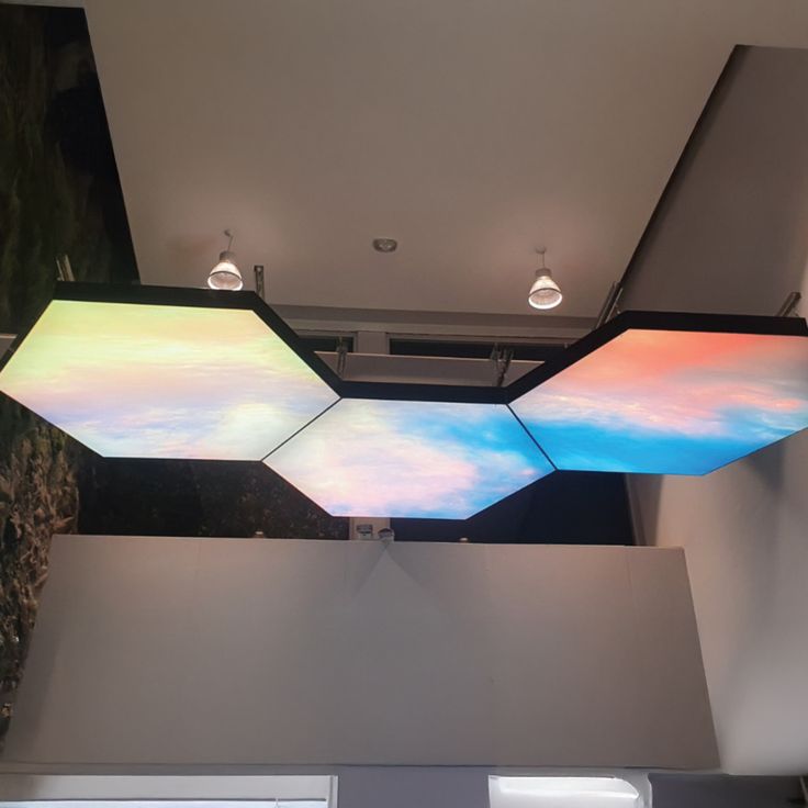Custom hexagon fabric light box ceiling with illuminated printed graphics in a modern interior