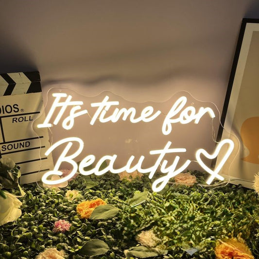 Its Time For Beauty Salon Neon Sign | Custom Neon Sign | Neon for Fashion Studio Neon sign with 'It's time for Beauty' text on a decorative setup with flowers and a clapperboard.