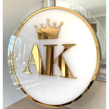 Decorative wall art with gold letters 'AIK' and a crown on a white background