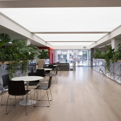 Large backlit fabric ceiling panels creating bright natural-looking illumination in a contemporary lobby