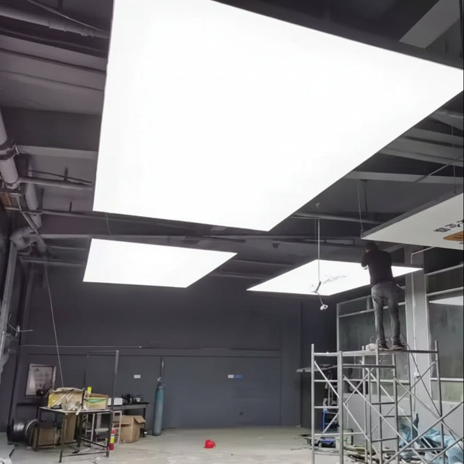 Large illuminated fabric ceiling panels providing diffused white lighting in a modern interior