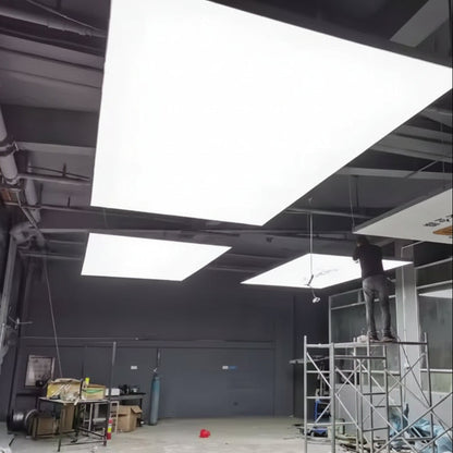 Large illuminated fabric ceiling panels providing diffused white lighting in a modern interior