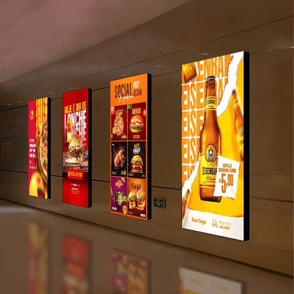 Vertical backlit LED advertising menu boards displaying food products and promotional offers in a restaurant
