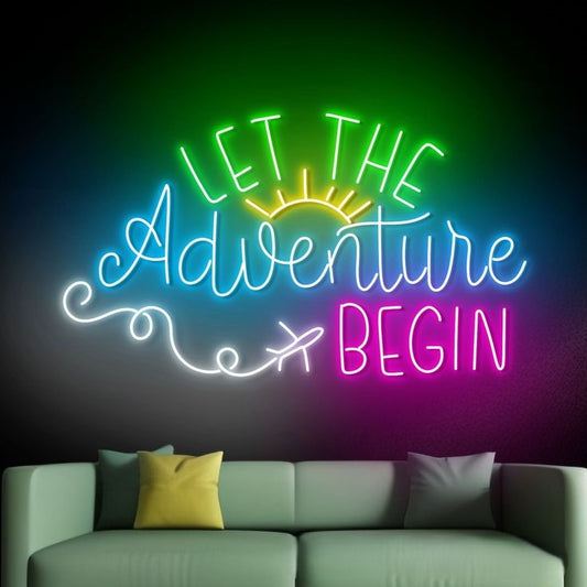 Let The Adventure Begin Neon Sign | Custom Neon Sign | Neon for Wall Decor Neon sign with 'Let the Adventure Begin' text on a dark wall above a sofa.