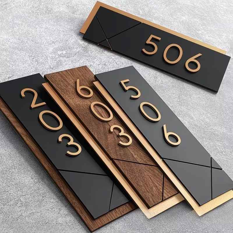 Contemporary custom house number sign featuring gold numerals on black and wood-effect panels, geometric detailing and illuminated wall-mounted designs.