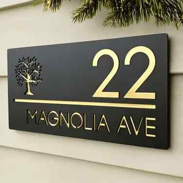Premium rectangular black house address sign with gold lettering, large house number, tree symbol and street name mounted on a modern home facade.