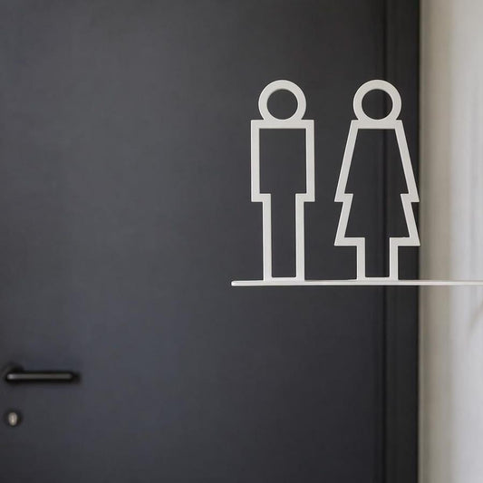 Minimalist white toilet signage with male and female pictograms on a projecting wall-mounted bracket displayed against beige stone, wooden and grey textured walls.