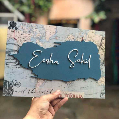 Custom travel-themed wall name plaque with a vintage map background, personalized family name and blue decorative panel displayed in a modern home interior.
