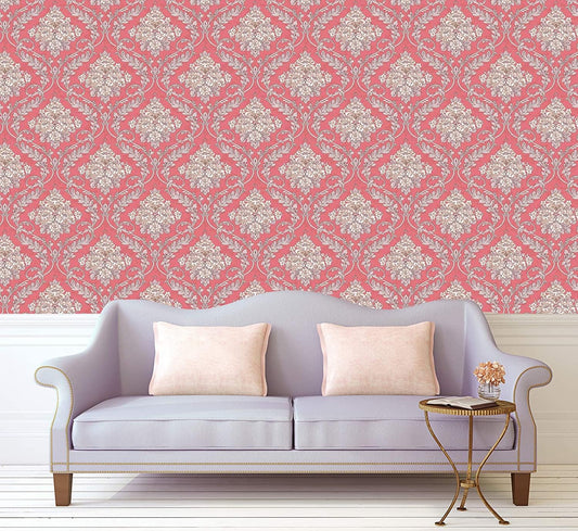 Decorative wallpaper with pink and white pattern behind a gray sofa with beige pillows.