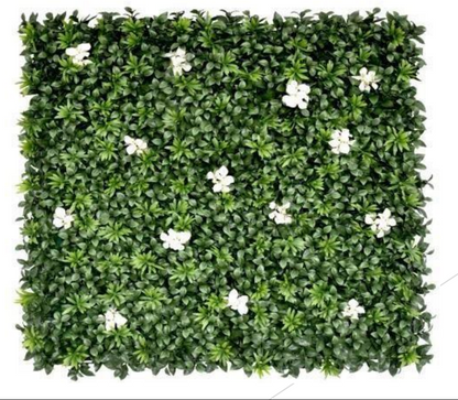 Decorative artificial green hedge wall featuring realistic foliage and white floral accents