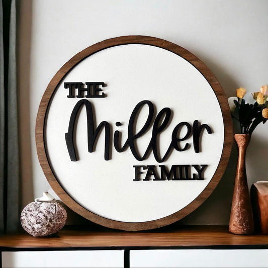 Circular wooden frame house name sign with elegant black script typography and personalized family lettering, displayed on modern stone and wooden entrance walls.