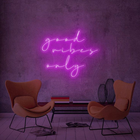 Purple Good Vibes Only Neon Sign | Custom Neon Sign | Neon for Wall Decor Neon sign with 'good vibes only' in a room with two orange chairs and a small table.