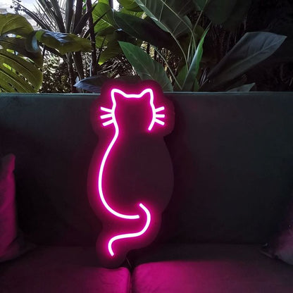 Sitting Cat Hand Neon Sign | Custom Neon Sign | Neon for Living Room Decor Neon pink cat shape on a dark background with plants