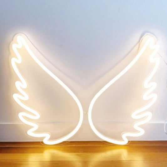 Warm Wings Neon Sign | Custom Neon Sign | Neon for Restaurants Decor, Banquet Neon light shaped like angel wings on a white wall.