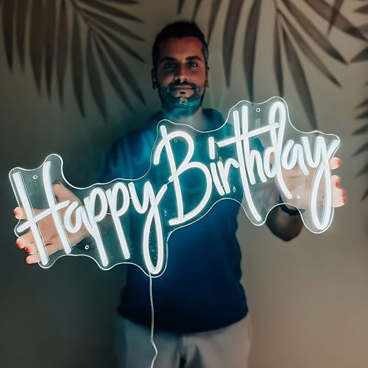 White Happy Birthday Neon Sign | Custom Neon Sign | Neon for Birthday Decor Man holding a neon 'Happy Birthday' sign with leafy background