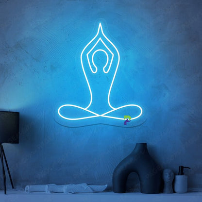 Yoga Neon Sign | Custom Neon Sign | Neon for Living Room Neon sign of a yoga pose on a textured blue wall with minimal decor.