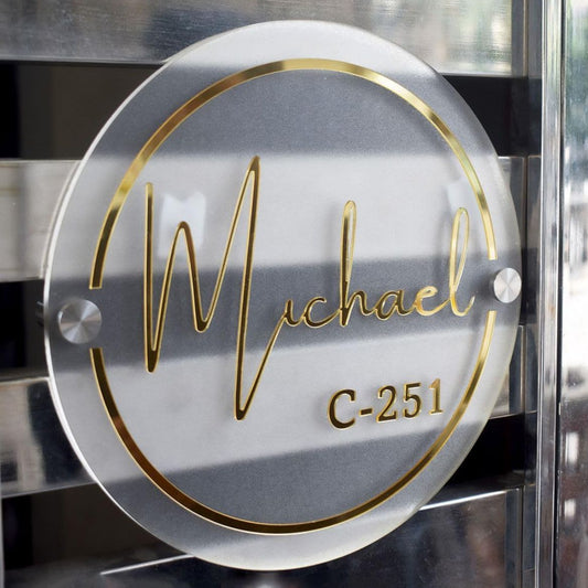 Custom acrylic circular name plate with gold lettering for modern door signage.