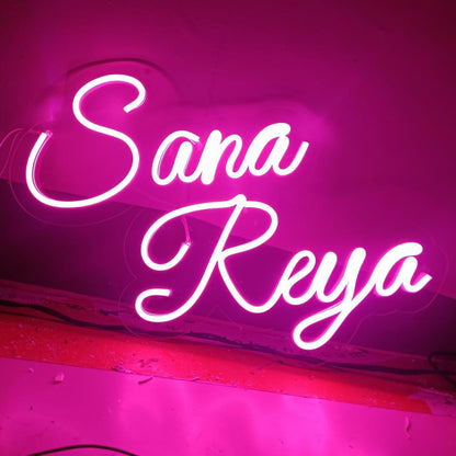 Neon sign with 'Sana Reya' text on a pink background