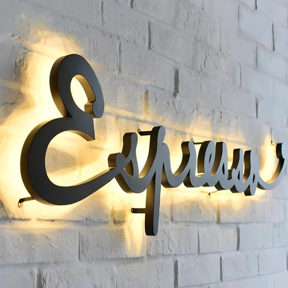 elegant cursive backlit LED letter sign warm white halo lighting wall signage brick background
