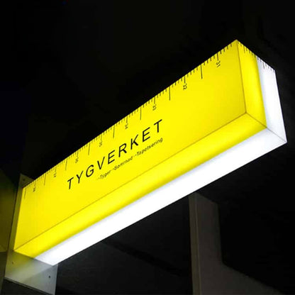 Illuminated projecting light box sign with custom LED blade signage for storefront branding.