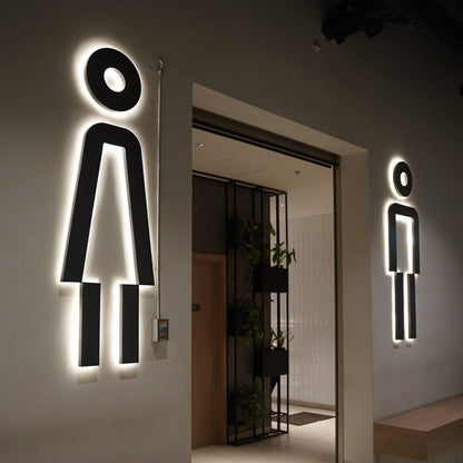 LED backlit restroom sign with glowing men and women icons
