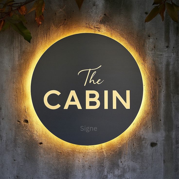 LED circular black acrylic logo sign with gold halo backlit round wall signage for cafe and cabin branding