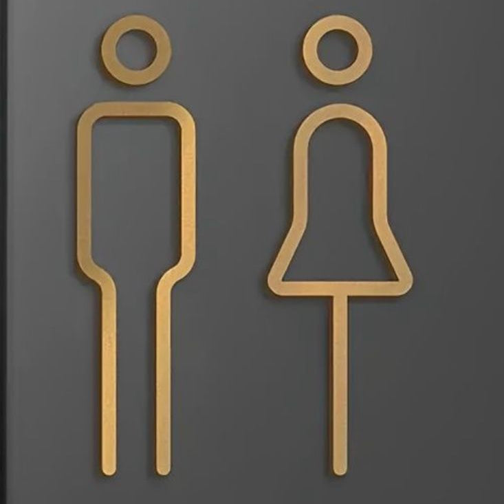 Luxury gold restroom symbols on dark wall
