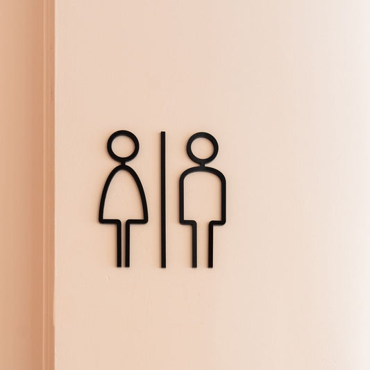 Minimal black restroom icon sign with men and women symbols on wall
