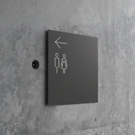 Minimalist directional restroom sign with arrow and washroom symbols for bathroom wayfinding.