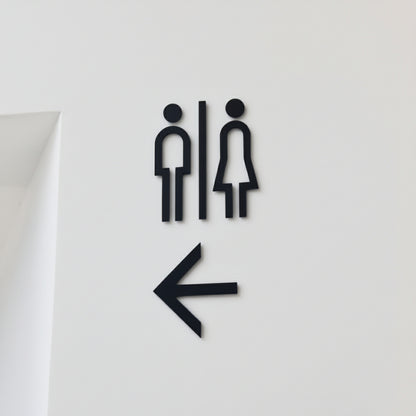 Minimalist restroom wall sign with left arrow
