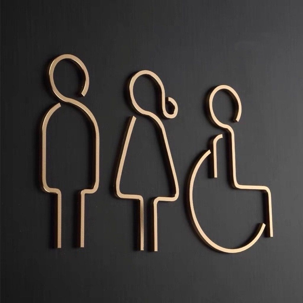 Modern accessible restroom sign with male female and wheelchair icons in gold finish
