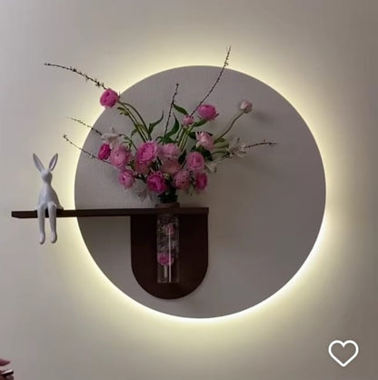 modern LED circle wall decor with vase shelf and pink flowers

