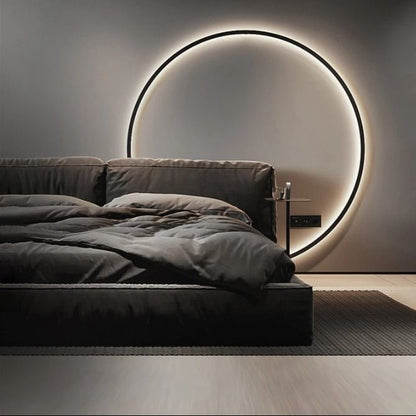 Modern LED circular wall light with halo backlit ring for bedroom headboard decor.