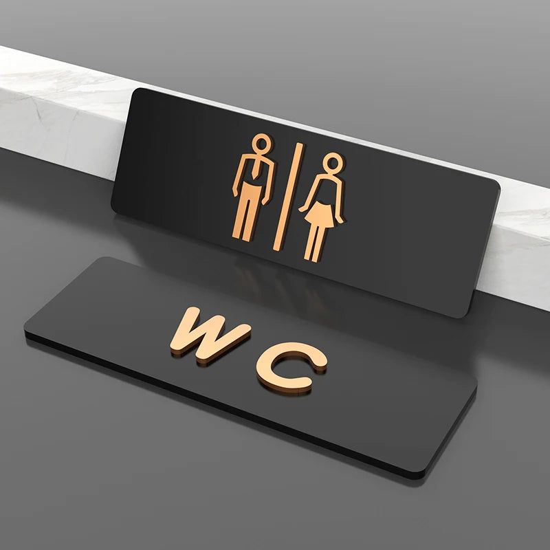 Modern WC restroom sign with men women icons in black and gold
